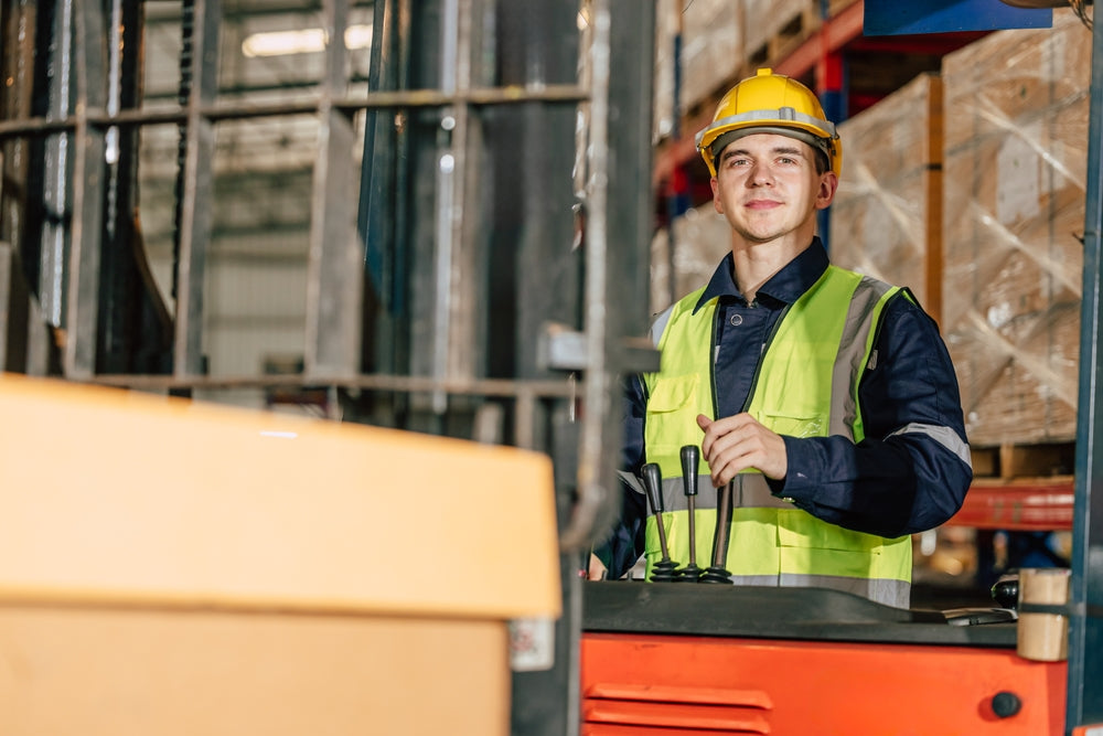 Lagermitarbeiter auf Gabelstapler vor Regalen